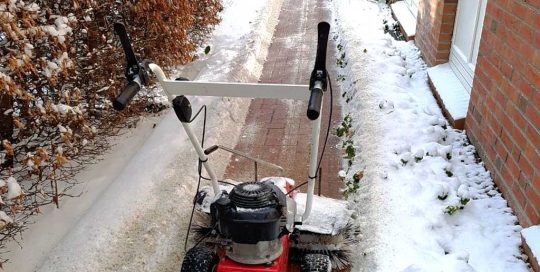 Schneeräumung einer Zuwegung mit Kehrbesen